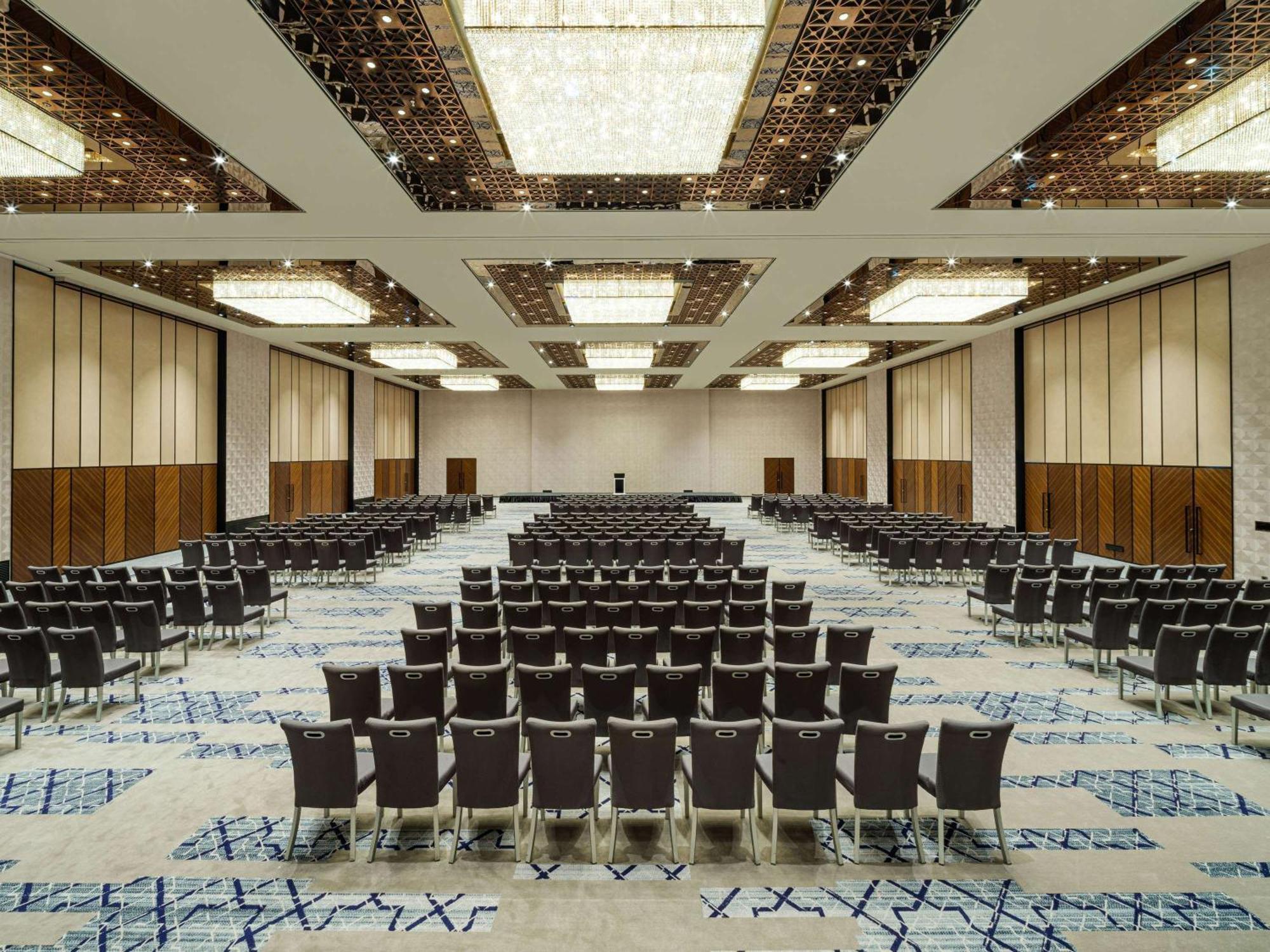 Swissotel The Bosphorus Istanbul Exterior photo The photo shows a large conference or banquet hall. It features numerous rows of chairs arranged in a neat, organized manner. The room has a modern aesthetic with high ceilings, decorative lighting fixtures, and a stylish carpet design. The walls are